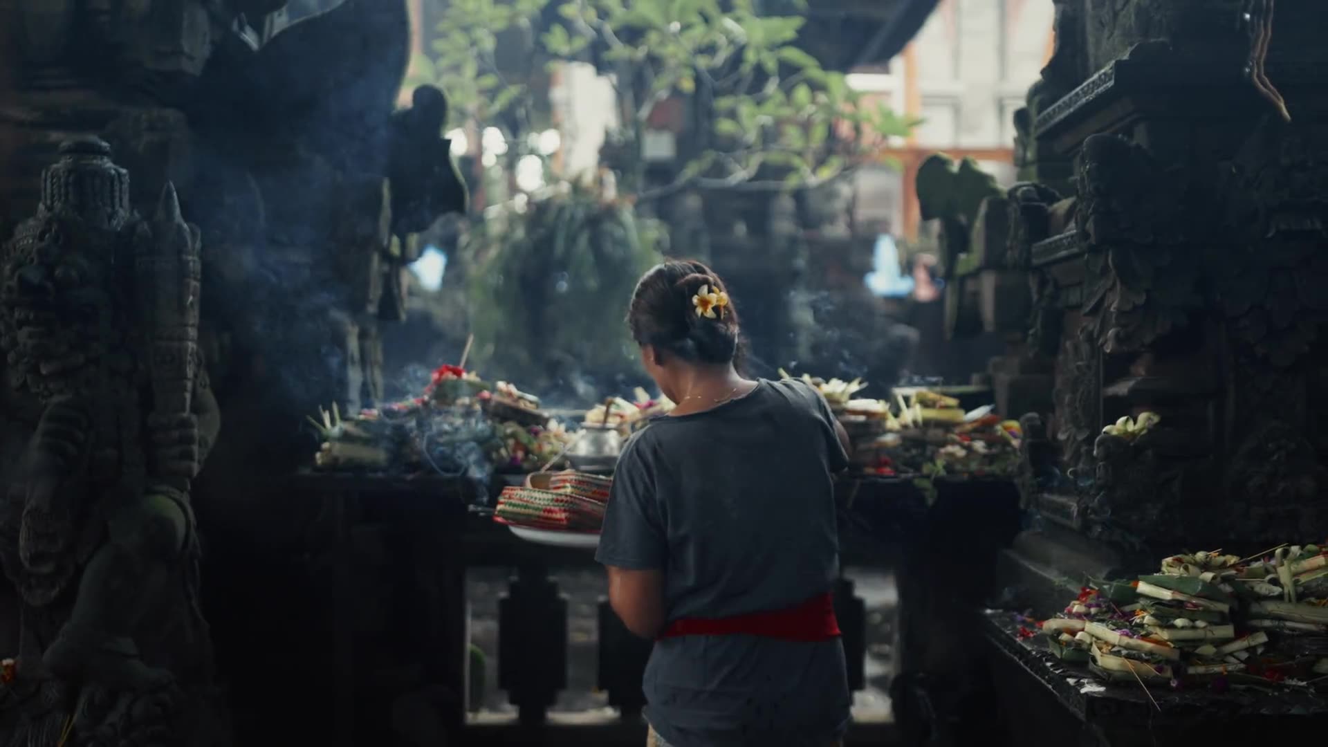 A canang sari offering placed at a temple statue in Bali