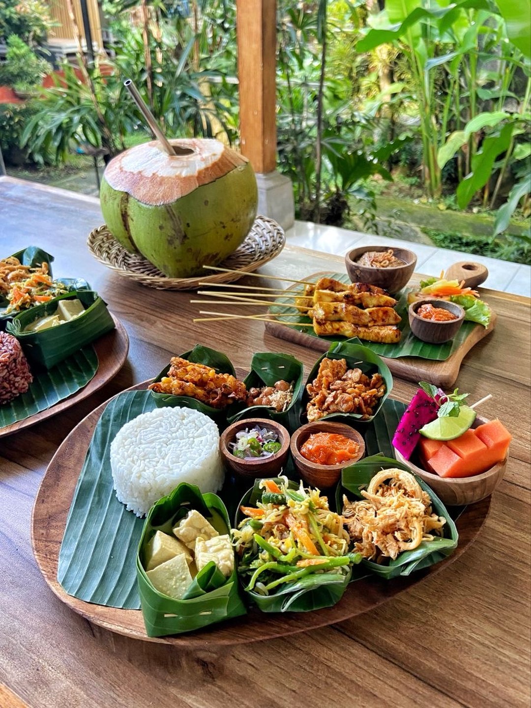 An Indonesian feast platter, sate and sambal on banana leaf