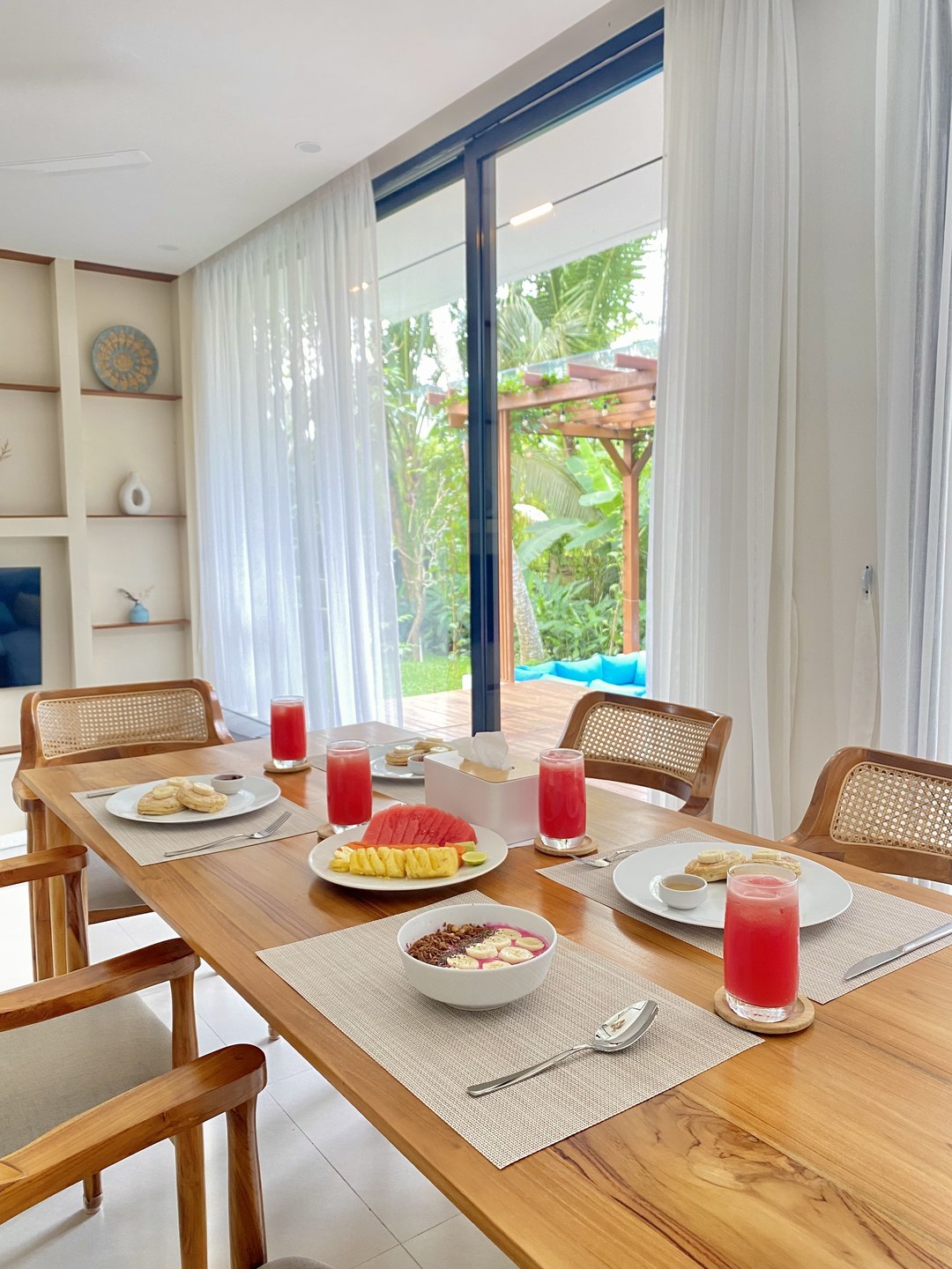 A villa table set for breakfast, opening to the garden