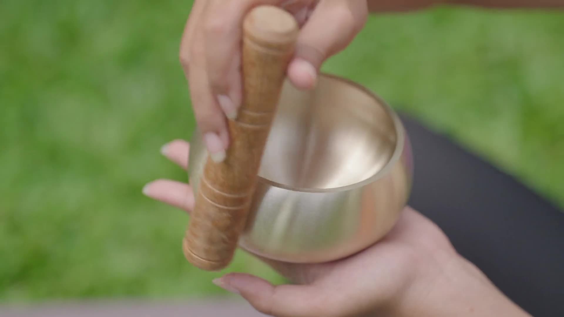 A practitioner playing a singing bowl in ritual