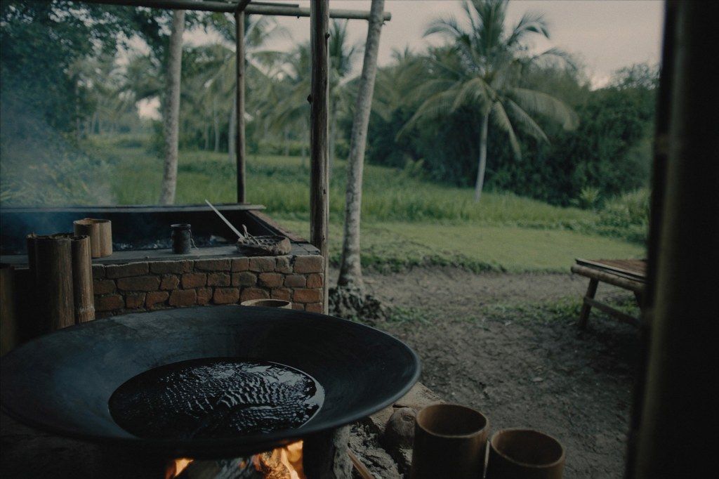 Palm sugar boiling over a wood fire at first light