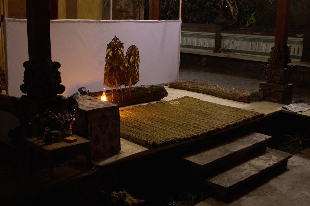 Shadow puppets against a lit screen for wayang kulit